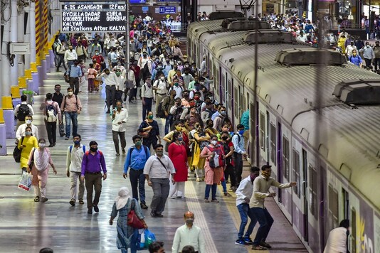 Commuters rush to board a suburban train at CSMT station prior to the night curfew, amid coronavirus pandemic, in Mumbai, Tuesday. (PTI)