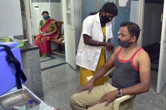 A medic administers the second dose of COVID-19 vaccine to a policeman during the third phase of inoculation drive. (Image: PTI)