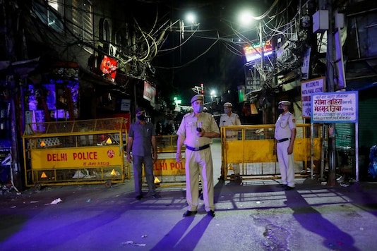Police officers stand guard on a deserted street during a curfew to limit the spread of the coronavirus disease (COVID-19), in New Delhi, India, April 6, 2021. REUTERS/Adnan Abidi
