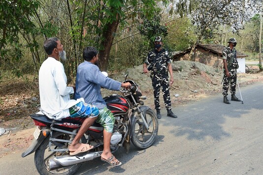 A security person instructs people outside a polling station in Bengal's South 24 Parganas district.
