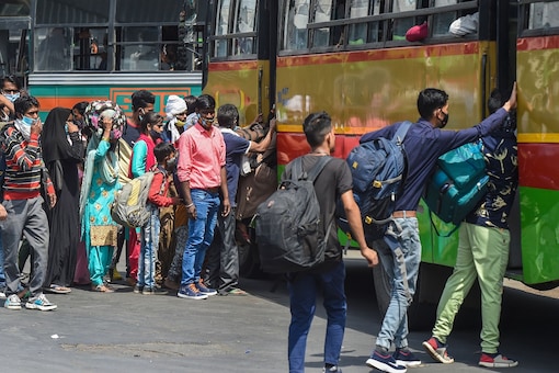 Passengers arrive at Anand Vihar Bus Terminal, as coronavirus cases surge across the national capital, in New Delhi, Wednesday. (PTI)