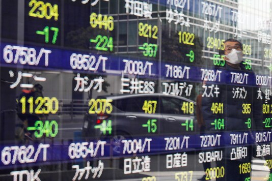 A man is reflected on a stock quotation board in Tokyo, Japan February 26, 2021. REUTERS/Kim Kyung-Hoon