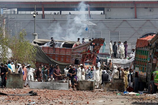 Supporters of banned Tehreek-e-Labiak Pakistan block a road and shout slogans protesting the arrest of their party leader Saad Rizvi in Lahore, Pakistan, on Sunday. (AP)