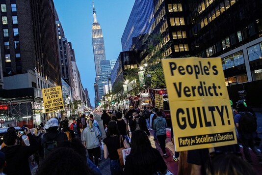 People march with signs on a street, after officer Derek Chauvin was found guilty of murdering George Floyd, in New York City, US. (Reuters)