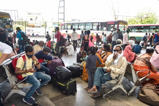 Migrants wait to board a bus at Alambagh Bus Station in Lucknow. (PTI)