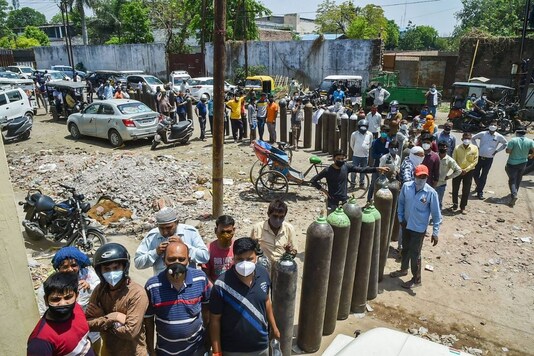 Kanpur: Family members of COVID-19 patients wait to fill their empty cylinders with medical oxygen outside an oxygen filling center, as demand for the gas rises due to spike in coronavirus cases, in Kanpur, Saturday, April 24, 2021. (PTI Photo/Arun Sharma)(