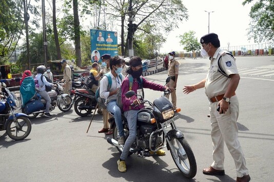 Security personnel stop commuters after curfew imposed due to surge in coronavirus cases, in Bhopal. (PTI)