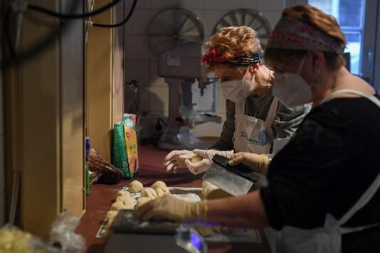 Two grandmothers prepare "Buchteln", an Austrian speciality filled with marmalade, in the kitchen of the Vollpension cafe, in Vienna, Austria.

(Credit: Joe Klamar/AP)