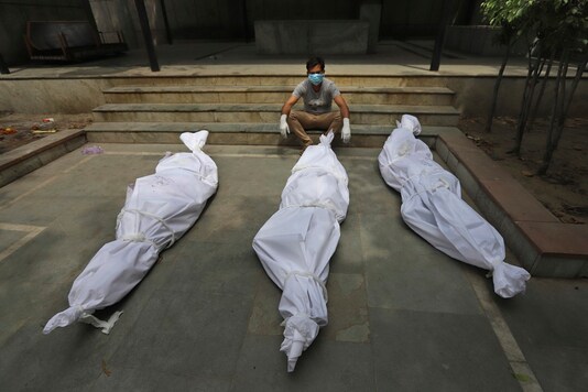 In this April 20, 2021, a man waits for the cremation of a relative who died of COVID-19, placed near bodies of other victims, in New Delhi. (AP)