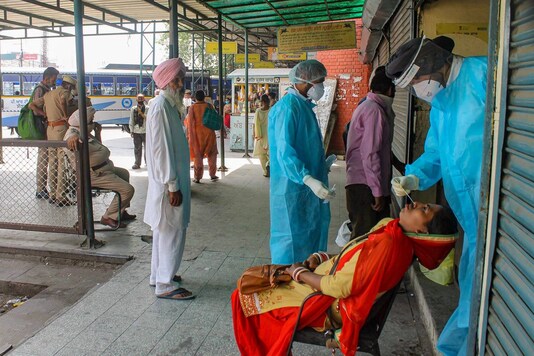 Health workers collect nasal swab samples of passengers. (PTI)