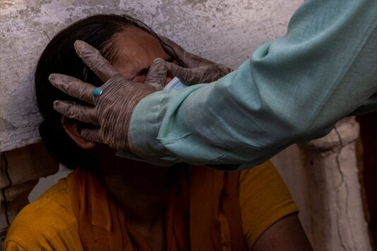 A woman is consoled after her mother died due to the coronavirus disease at a crematorium ground in New Delhi. Reuters