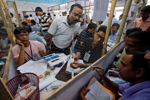 An election staff member shows a paper to polling agents after opening an EVM inside a vote-counting centre in India. Representative photo: Reuters)
