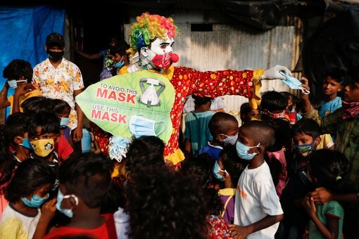 A man distributes face masks to children in a slum. (Reuters)