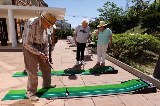Residents Paul Souveton, Bernard Sellier and Frederique Benichou play mini golf at "Les Figuiers" retirement home (EHPAD - Housing Establishment for Dependant Elderly People) amid the coronavirus disease (COVID-19) pandemic, in Villeneuve-Loubet, France, May 5, 2021. Picture taken May 5, 2021. REUTERS/Eric Gaillard