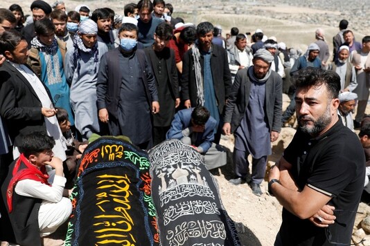 Relatives mourn next to coffins of two victims of yesterday's explosion during a mass funeral ceremony in Kabul, Afghanistan May 9, 2021. REUTERS/Stringer
