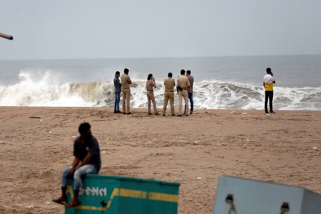 Police personnel guard near the coastline ahead of the landfall of Cyclone Tauktae in Gujarat's Veraval on May 17. (Image: PTI)