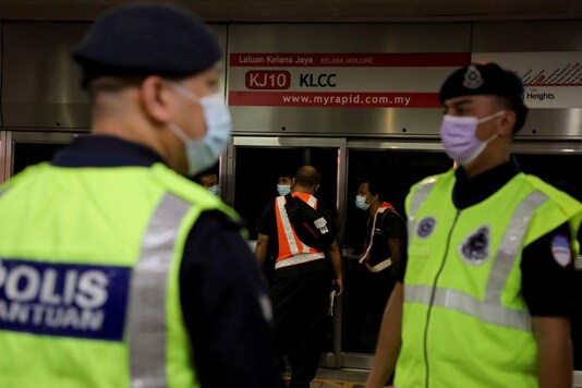 Police officers stand guard outside the crash scene of two metro light rail trains that collided in an underground tunnel at a station in Kuala Lumpur, Malaysia May 25, 2021. REUTERS/Lim Huey Teng
