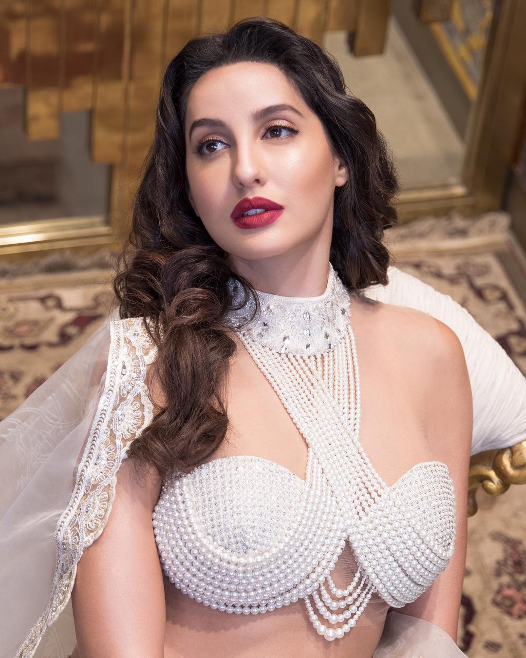 Nora Fatehi keeps it sensuous in the pearl-encrusted halter-style blouse. (Image: Instagram)