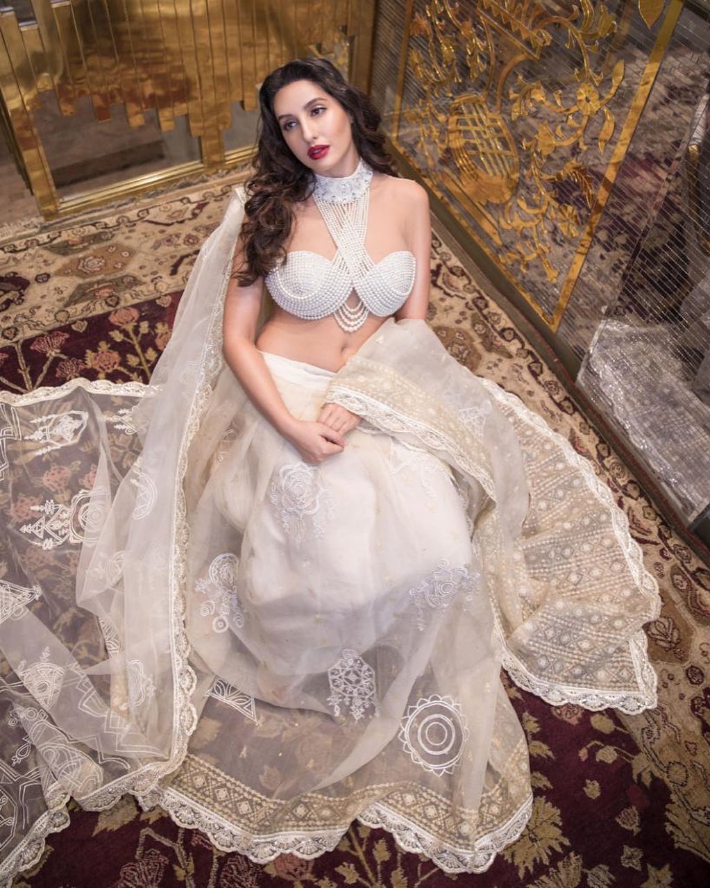 Nora Fatehi gives queen vibes in the white lehenga with the pearl blouse.
