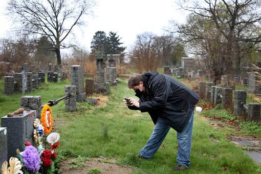 Brian Walter takes a photograph of his late father's gravestone at the All Faiths Cemetery in the Queens borough of New York. 

(AP Photo/Jessie Wardarski)
