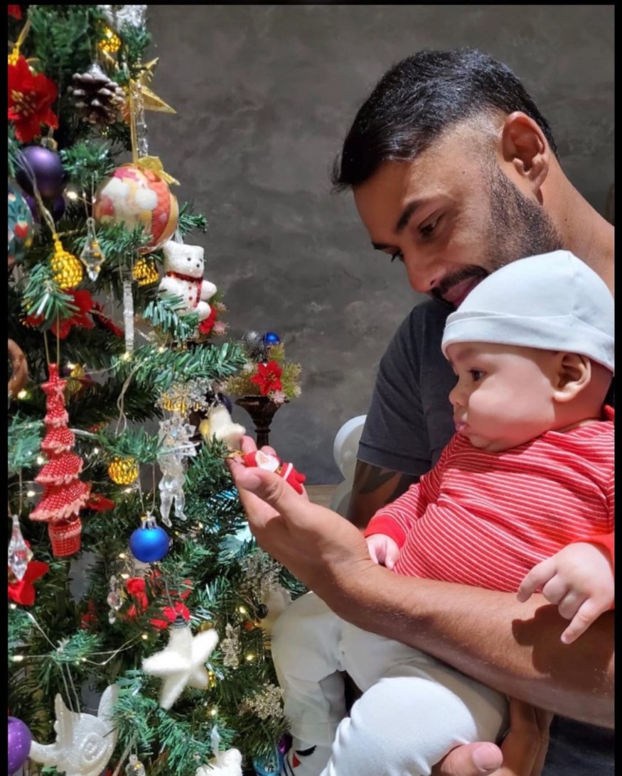  Binny holds his son while showing him a Christmas tree. (Image: Instagram)