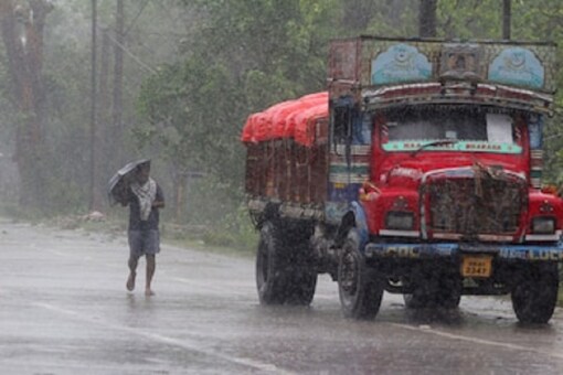 A man walks in the rain (File photo/AP)

