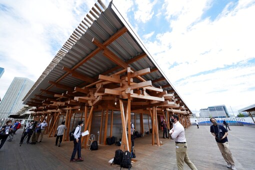 Journalist walk at the Village Plaza near Tokyo 2020 Olympic and Paralympic Village Sunday (AP)