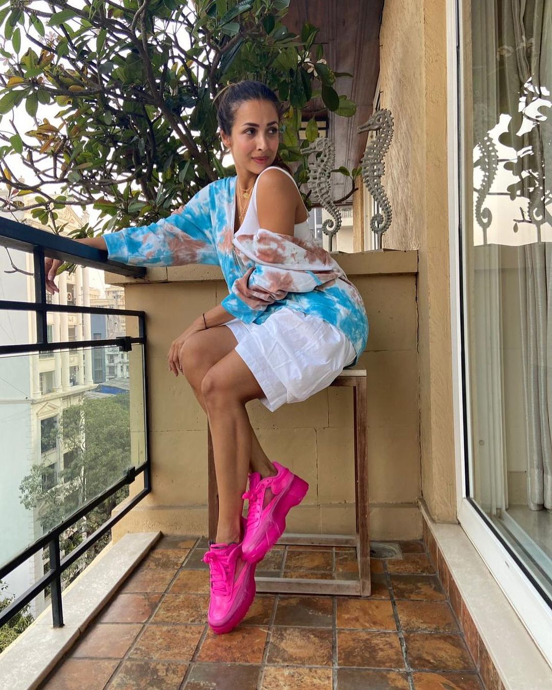  Malaika Arora keeps it simple yet fashionable in the tie-dye jacket with the white shorts and bright pink shoes. (Image: Instagram)