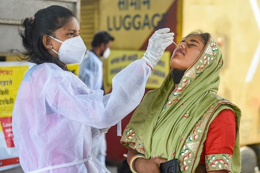 A BMC health worker collects swab sample of a passenger for COVID-19 test, at a station in Mumbai, July 2. (PTI)