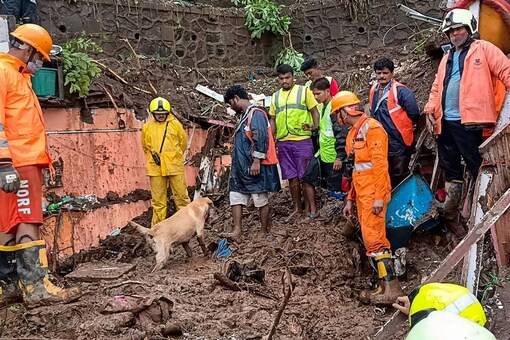 Firemen and rescue workers after a wall collapsed on some shanties in Chembur's Bharat Nagar area due to a landslide, in Mumbai. (PTI)