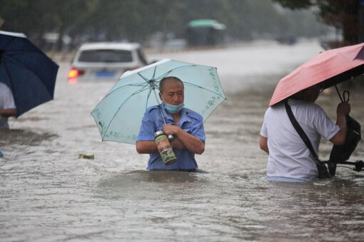 Residents wade through floodwaters on a flooded road amid heavy rainfall in Zhengzhou, Henan province, China.