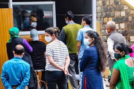 People wait in queues for their COVID-19 test, at a regional hospital in Kullu, Thursday. (PTI)