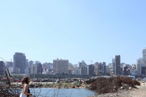A woman walks on rubble at the site of last year's Beirut port blast, in Beirut, Lebanon. Reuters