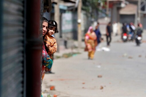 A Kashmiri woman holds a girl as they watch a protest after a gun battle between suspected militants and Indian security forces in Srinagar. (REUTERS/Danish Ismail)