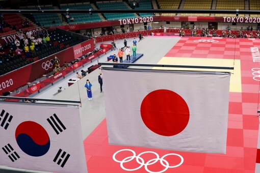 The flag of Japan, center, is raised along with the flags of South Korea (AP)
