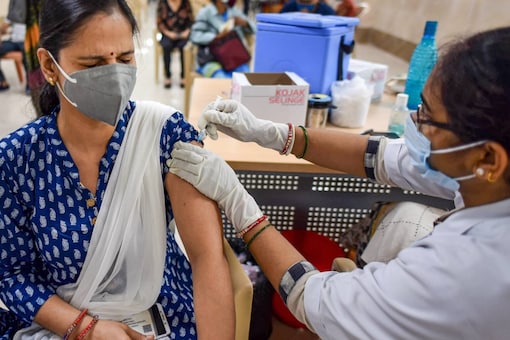 A health worker administers COVID-19 vaccine to a beneficiary, at Moti Lal Nehru Medical College, in Prayagraj. (PTI Photo)