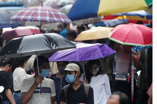 People walk through a crowded market on a rainy day amidst the spread of the coronavirus disease (COVID-19) in Mumbai, India, July 14, 2021. REUTERS/Francis Mascarenhas