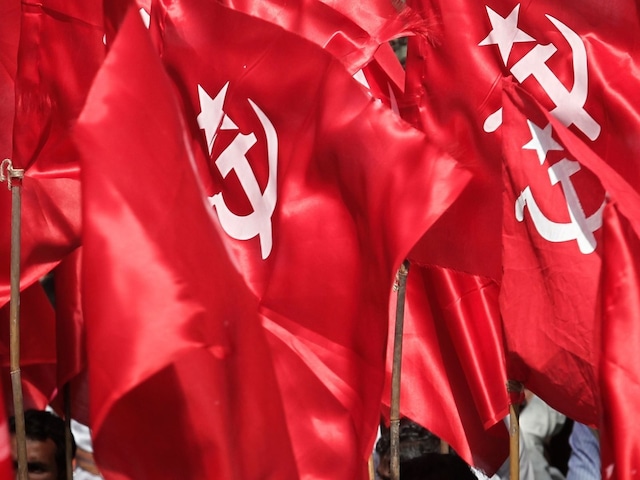 An activist from the Communist Socialist Unity Centre of India (SUCI) sits under his party's flags during a protest in New Delhi March 14, 2012. Thousands of activists on Wednesday protested against the rising prices of essential commodities and corruption, activists said. REUTERS