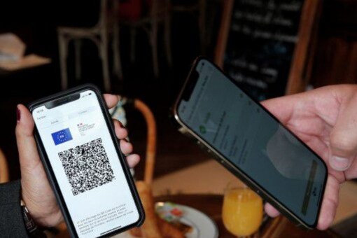 
A woman shows a COVID-19 health pass in a cafe as France brings in tougher restrictions where a proof of immunity will be required to access most of the public spaces or to travel on an inter-city train in Paris, France, August 9, 2021. REUTERS/Benoit Tessier