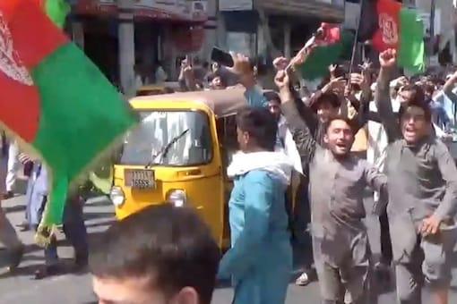 एक वीडियो से ली गई इस स्क्रीन ग्रैब में लोग 18 अगस्त, 2021 को जलालाबाद, अफ़ग़ानिस्तान में तालिबान विरोधी विरोध प्रदर्शन में हिस्सा लेते हुए अफ़ग़ान झंडे लिए हुए हैं।  (छवि: पझवोक अफगान समाचार / रायटर के माध्यम से हैंडआउट)