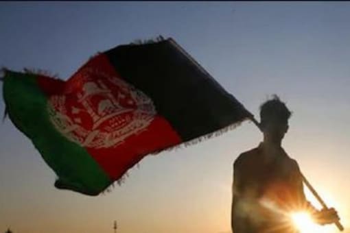 अफ़ग़ानिस्तान का राष्ट्रीय ध्वज धारण करने वाला एक व्यक्ति, जिसका उपयोग प्रतिनिधित्व के उद्देश्य से किया जाता है।  (एपी फोटो)