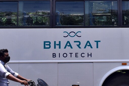 A man rides his motorbike past a parked bus of India's biotechnology company Bharat Biotech outside its office in Hyderabad, India July 3, 2020. REUTERS/Stringer
