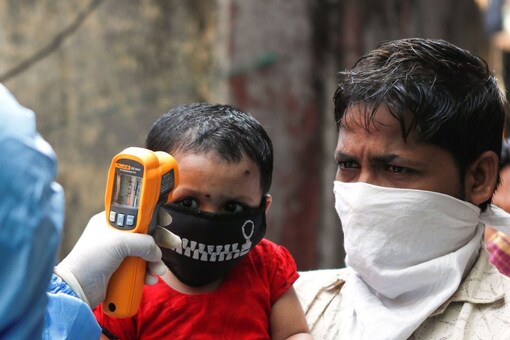 A doctor checks temperature of residents from Dharavi in Mumbai, India, April 11, 2020. (Reuters)