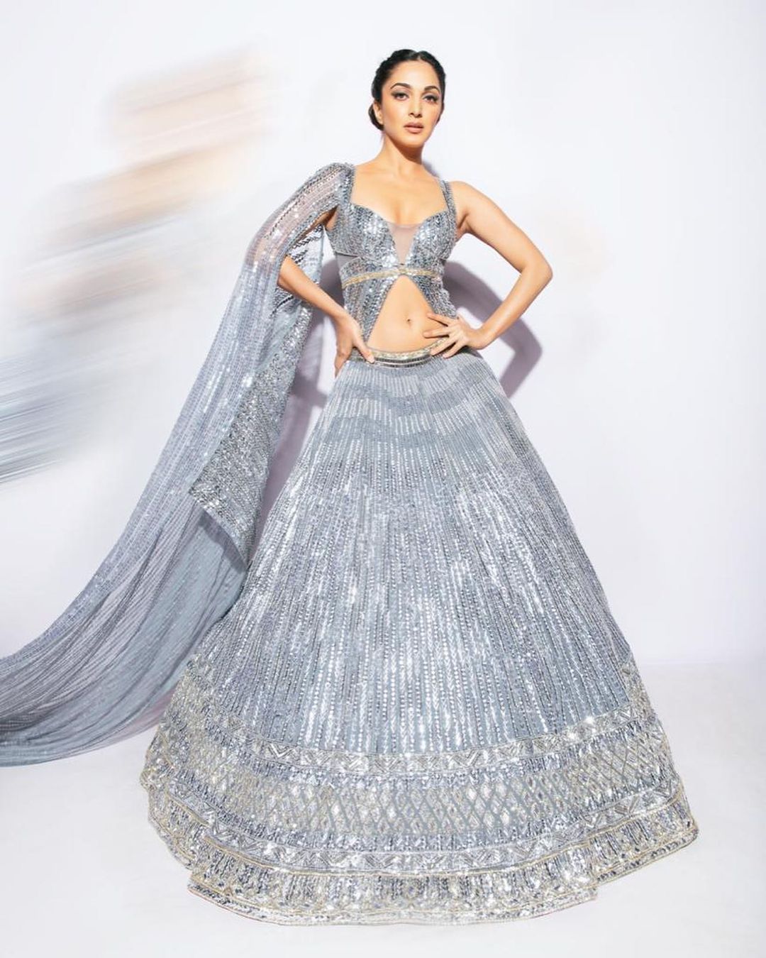 Kiara Advani strikes a confident pose in the shimmering silver lehenga.