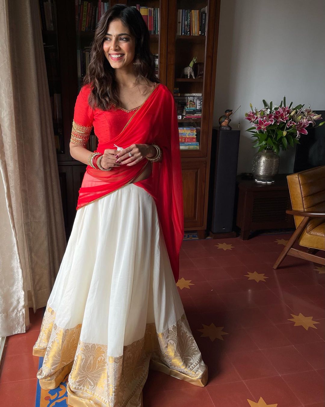 Malavika Mohanan looks gorgeous in the red and white semi-saree.