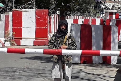 A Taliban fighter stands guard at the entrance of the police headquarters in Ghazni on August 12, 2021. (AFP)