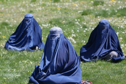 Afghan women wait to receive free wheat donated by the Afghan government. (Reuters)