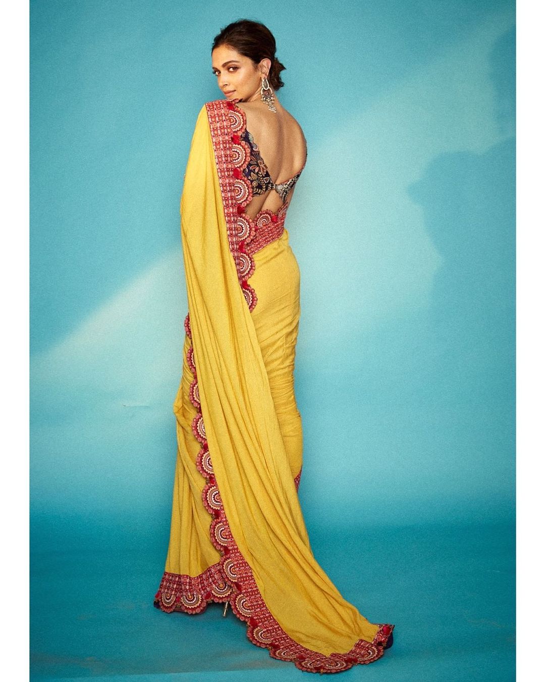Deepika Padukone looks graceful in the yellow saree with the pink border.