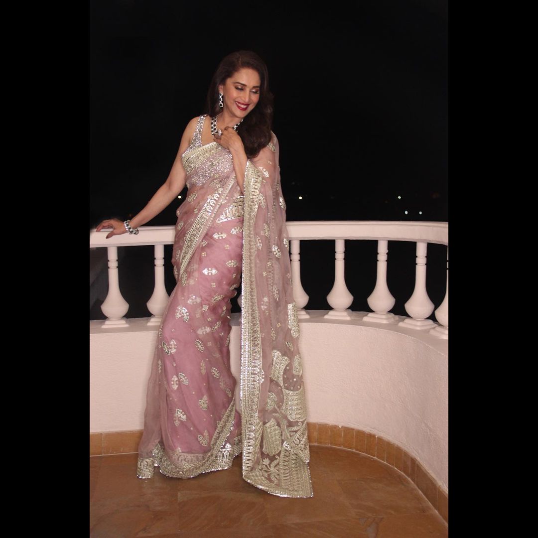 Madhuri Dixit looks lovely in the pastel pink saree.