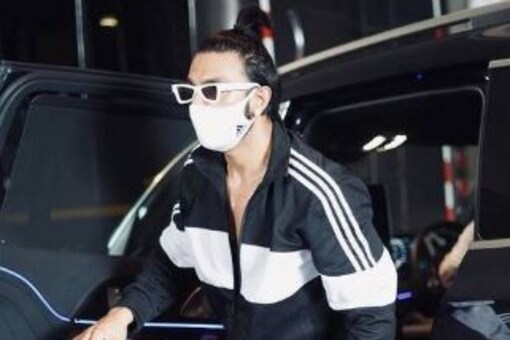 Ranveer Singh looks as stylish as ever in a black and white tracksuit teamed with white sneakers, white sunglasses and a white mask.